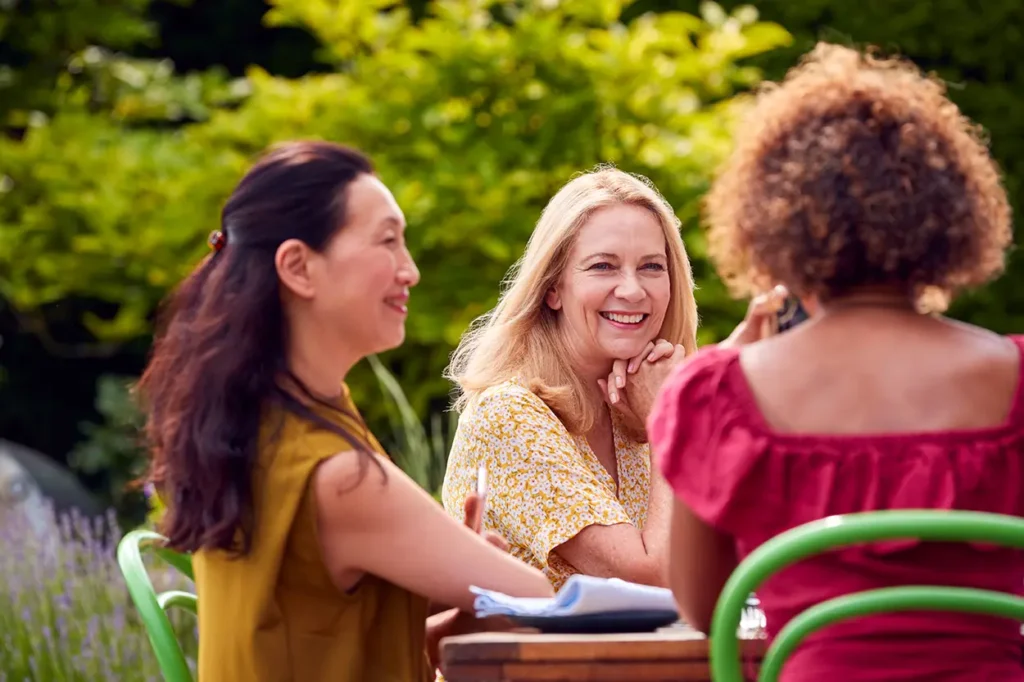 group of mature female friends talking around tabl 2023 11 27 05 02 29 utc